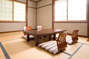 松本诗意酒店的一间带木桌和椅子的用餐室