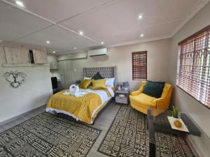 哈里史密斯Le-n-Biki Air B&B的一间卧室配有一张床和一张黄色椅子