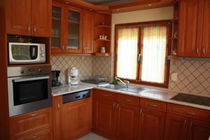 巴拉顿诺尔马迪Manner villa的一间带木制橱柜和微波炉的厨房