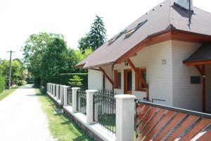 巴拉顿诺尔马迪Manner villa的路边有栅栏的白色房子