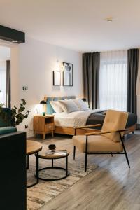 华沙ORSO Rooms & Apartments - LoftAffair Collection的一间卧室配有一张床、一张沙发和一张桌子