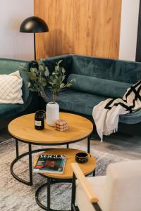 华沙ORSO Rooms & Apartments - LoftAffair Collection的客厅配有绿色沙发和桌子