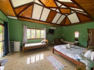 拉迪格岛Elje Villa的一间卧室设有绿色的墙壁和木制天花板