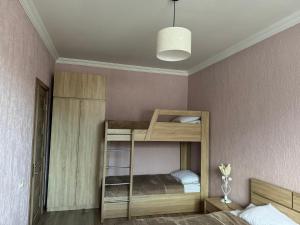 博尔若米Villa Borjomi的客房设有两张双层床和一盏灯。