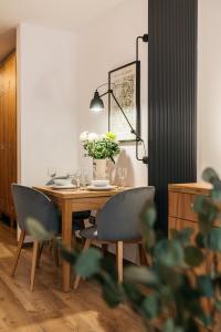 华沙ORSO Rooms & Apartments LoftAffair Collection的餐桌、椅子和花瓶