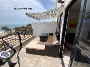 BijiloLuxury & Comfort, with Pool and Ocean Views的阳台配有沙发和桌子,海滩