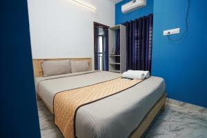 科泽科德Twinn Waves Calicut的一间卧室设有两张床和蓝色的墙壁