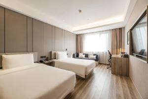 杭州杭州黄龙亚朵酒店的酒店客房,设有两张床和一张沙发