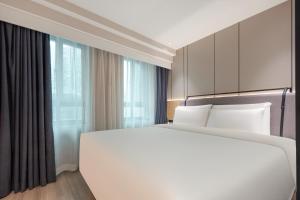 上海上海徐家汇万体馆亚朵X酒店的卧室设有一张白色大床和一扇窗户。