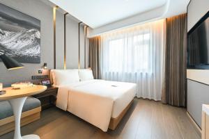 北京北京鼓楼亚朵酒店的配有一张床、一张桌子和一张桌子的酒店客房