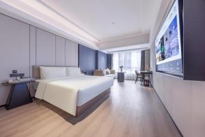 深圳深圳罗湖笋岗宝能中心亚朵X酒店的卧室配有一张白色大床和一台平面电视。
