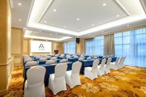 宝安深圳宝安机场航城亚朵X酒店的一个带椅子和投影屏幕的会议室