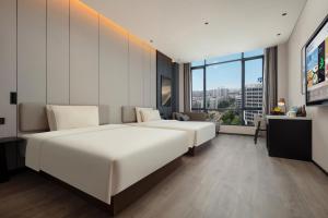 佛山佛山禅城张槎亚朵酒店的酒店客房设有两张床和大窗户。
