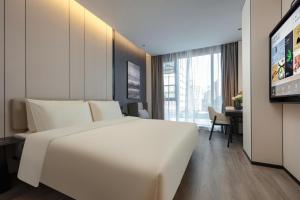 杭州杭州浙大城市学院西联桥亚朵酒店的卧室配有一张白色大床和一张书桌