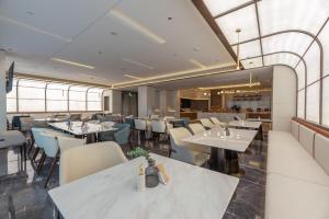 厦门厦门两岸金融中心亚朵S酒店的餐厅设有白色的桌椅和窗户。