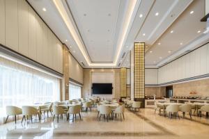 宝安深圳宝安机场航城亚朵X酒店的一间会议室,配有桌椅和屏幕