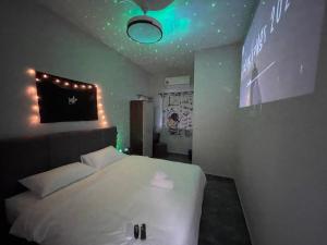 新山R8 Hotel-style Room With Projector #1min Walk to Ksl City Mall的卧室配有白色床和天花板上的灯。