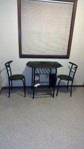 尚佩恩CCS LLC的窗户间里的一张桌子和两把椅子