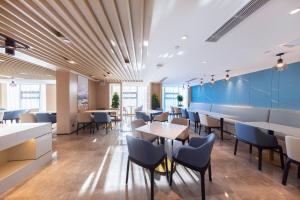 昆明昆明高铁南站大学城亚朵酒店的餐厅拥有蓝色的墙壁和桌椅