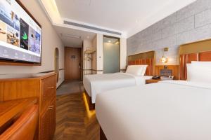 大兴北京大兴机场野生动物园亚朵X酒店的酒店客房设有两张床和一台平面电视。