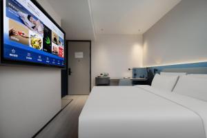 广州广州番禺广场富华东路轻居酒店的配有一张床和一台平面电视的酒店客房