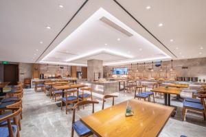 北京北京雍和宫和平里亚朵X酒店的一间空餐厅,配有木桌和椅子