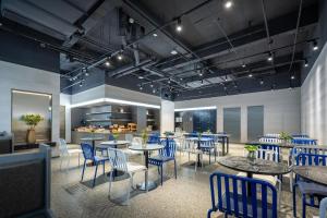 杭州杭州西湖武林广场环城北路轻居酒店的一间配备有蓝色椅子和桌子的用餐室