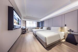 深圳深圳罗湖笋岗宝能中心亚朵X酒店的配有一张床和一台平面电视的酒店客房