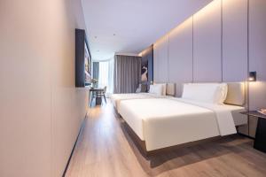 北京北京北清路永丰科技园亚朵酒店的酒店客房设有两张床和一张桌子。
