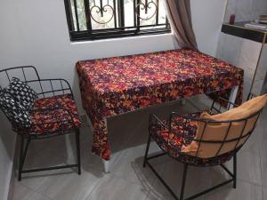 恩德培Mini Lookout Entebbe的桌子和两把椅子以及一张桌子和一把椅子