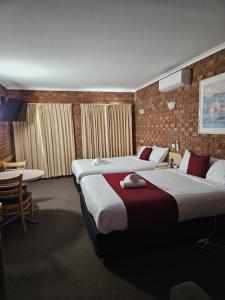 谢珀顿庭院汽车旅馆的酒店客房设有两张床和一张桌子。