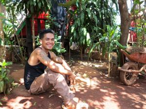 邦隆Ratanakiri Homestay & Jungle Trek的坐在花园内蹲在地上的人