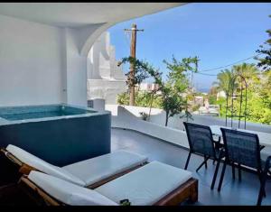 弗通The Muses of Santorini Private Jacuzzi Suites的配有浴缸、椅子和桌子的庭院