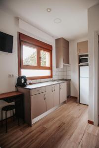 ZaratánPoloestudios的厨房配有白色橱柜和窗户。