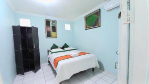 斯勒曼Homestay Simply Homy dekat Tugu Jogja dan Monjali的蓝色客房中一间带床的卧室