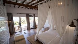 法拉尔雅Lov Faralya Beach & Nature Retreat的卧室配有白色天蓬床和窗户