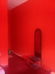 汉班托塔Sayonara Resort的红色的房间,设有长凳和红色的墙壁