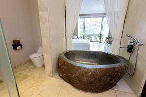 乌布Tejaprana Resort & Spa的浴室配有大型木制浴缸及卫生间