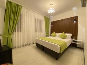 博兹贾阿达岛My Dream Bozcaada的一间卧室配有一张带绿色床单的大床