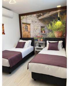 博兹贾阿达岛My Dream Bozcaada的一间卧室设有两张床和石墙