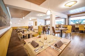 索普拉布扎诺APIPURA hotel rinner的餐厅设有木桌和黄色椅子