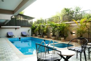 莫尔吉姆Ariena by Spree Hotels Goa的一个带椅子的庭院和一个游泳池