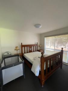 卡尔斯Cowes Holiday Home的一间卧室设有一张木床和一个窗户。