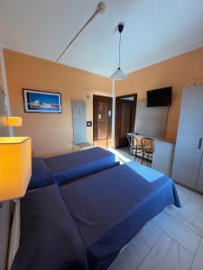 布林迪西阿普罗多酒店的一间带蓝色床的卧室和一间厨房