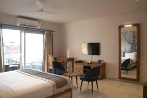 莫尔吉姆Ariena by Spree Hotels Goa的酒店客房带一张床、一张书桌和一面镜子