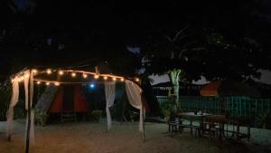 爱妮岛SHALOM CAMP的帐篷和桌子,晚上有灯