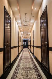 杜尚别ORIYO DUSHANBE HOTEL的走廊上设有门,走廊上铺有地毯