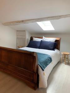 特雷利萨克Maison de famille 24的一间卧室配有一张带蓝色枕头的木床。