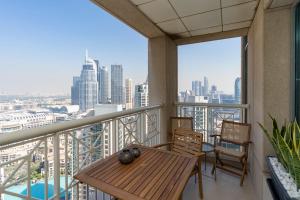 迪拜Prestige Living 2BR with Full Burj Khalifa and Fountain View by Auberge的市景阳台配有桌椅。