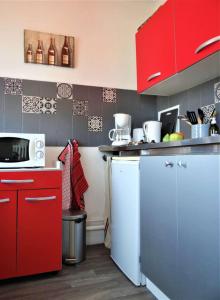 沙特尔Le Clos Pichot - Studio avec balcon, parking privé - 5mn Gare的厨房配有红色橱柜和白色冰箱